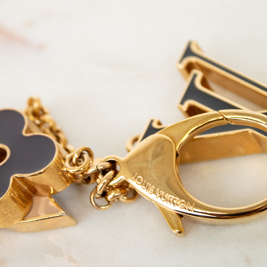 Gold keychain with charms on a marble surface