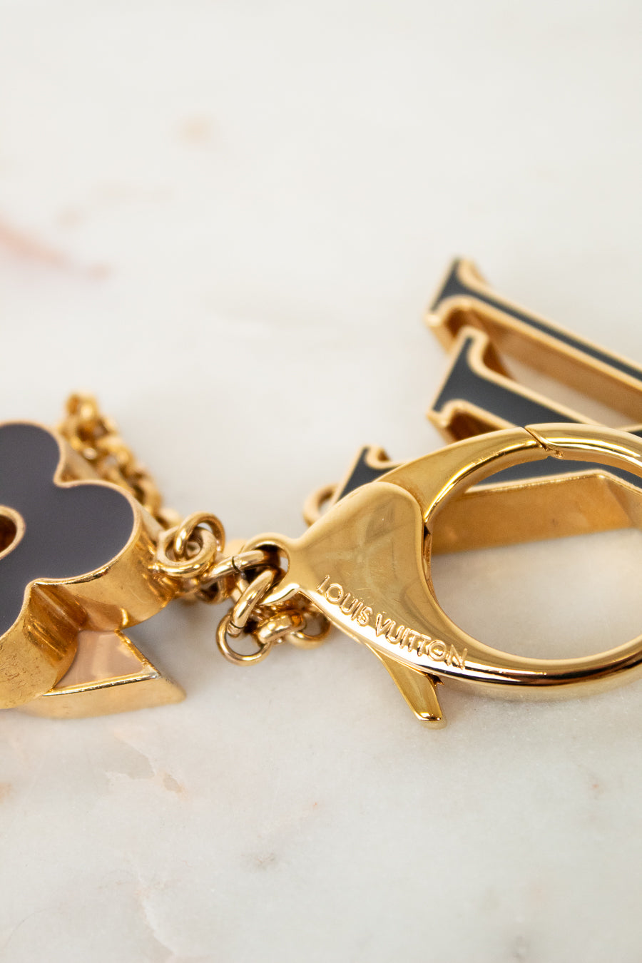 Gold keychain with charms on a marble surface