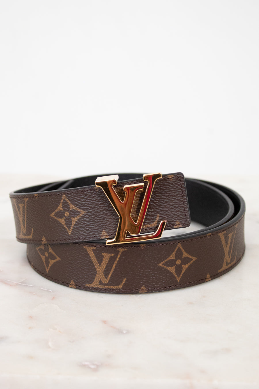Louis Vuitton belt with monogram pattern on a light background