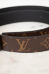 Louis Vuitton belt close up with monogram pattern on a marble surface