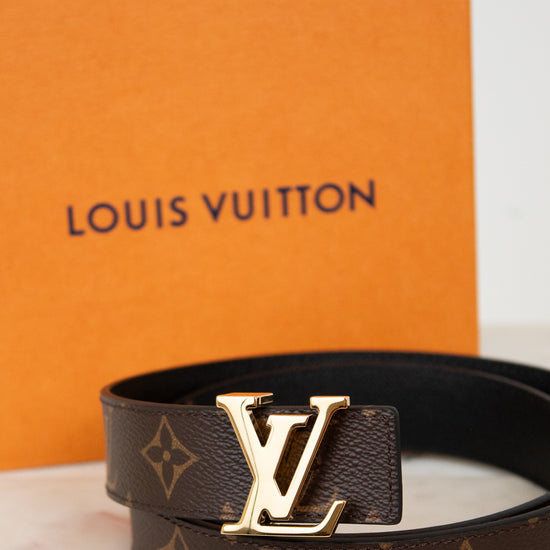 Louis Vuitton belt with monogram pattern and gold buckle with orange box background