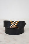 Black belt with a two tone buckle on a light marble background