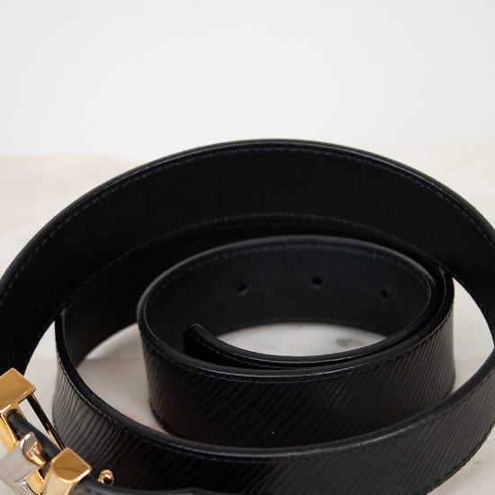 Black belt with two tone buckle on a marble surface