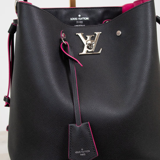Louis Vuitton black pebbled leather hobo bag with bright pink lining and trim, featuring a silver-tone LV logo clasp and a hanging leather tag.