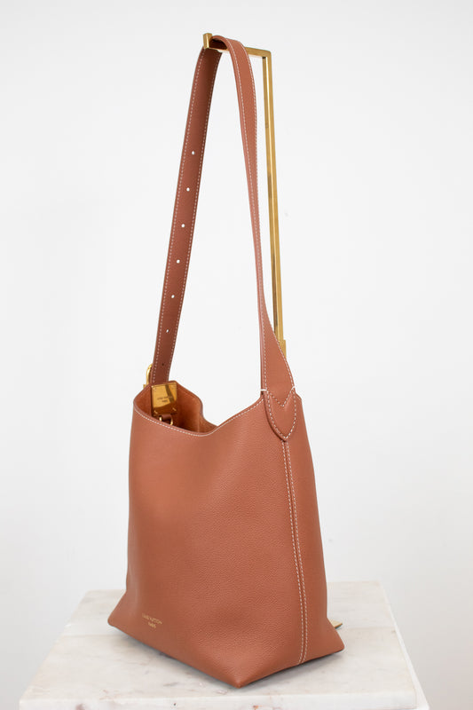 Brown leather handbag with gold accents on a white background