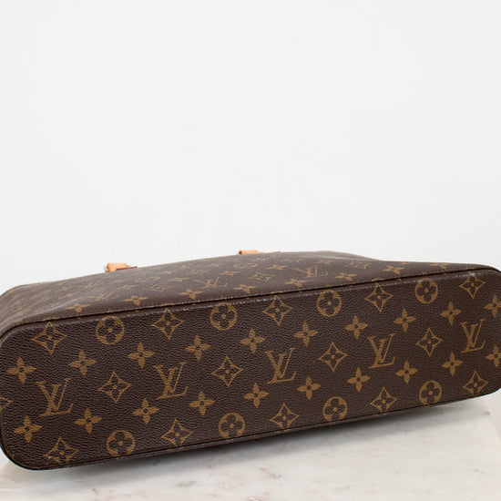 Brown monogram handbag with tan handles on a white background