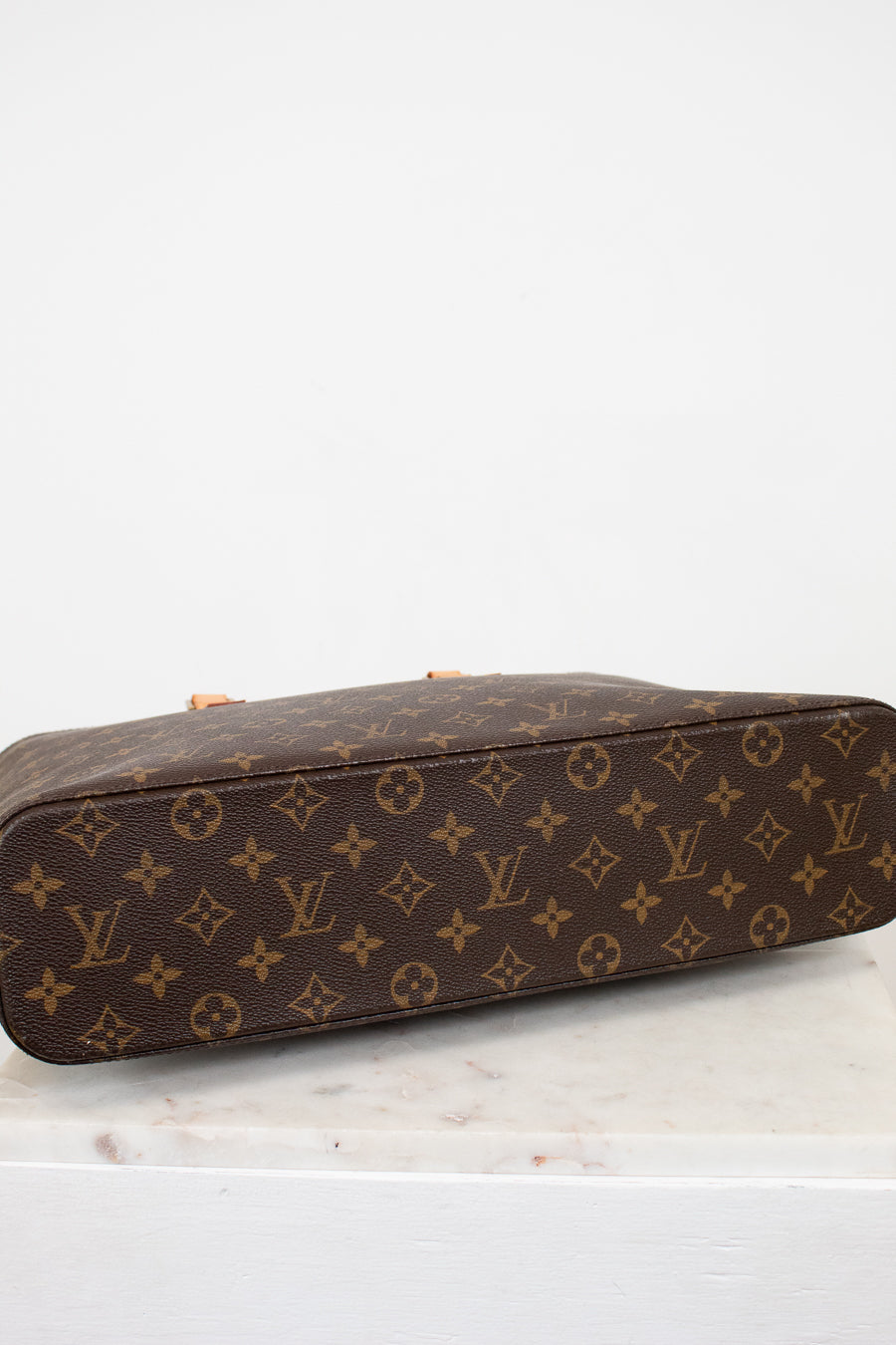 Brown monogram handbag with tan handles on a white background