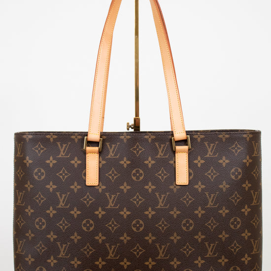 Brown monogram handbag with tan handles on a white background