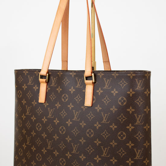 Brown monogram handbag with tan handles on a white background