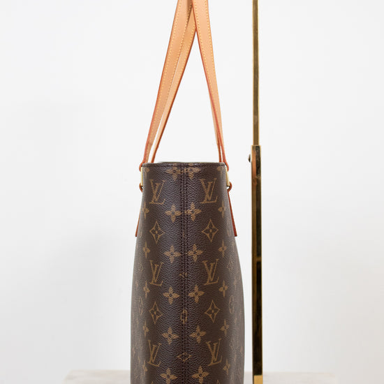 Brown monogram handbag with tan handles on a white background