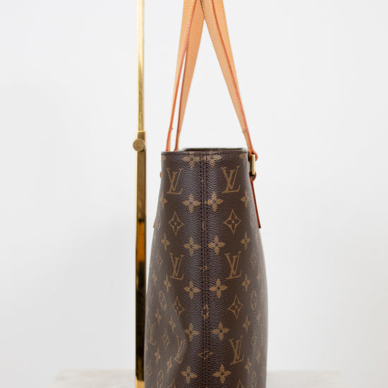 Brown monogram handbag with tan handles on a white background