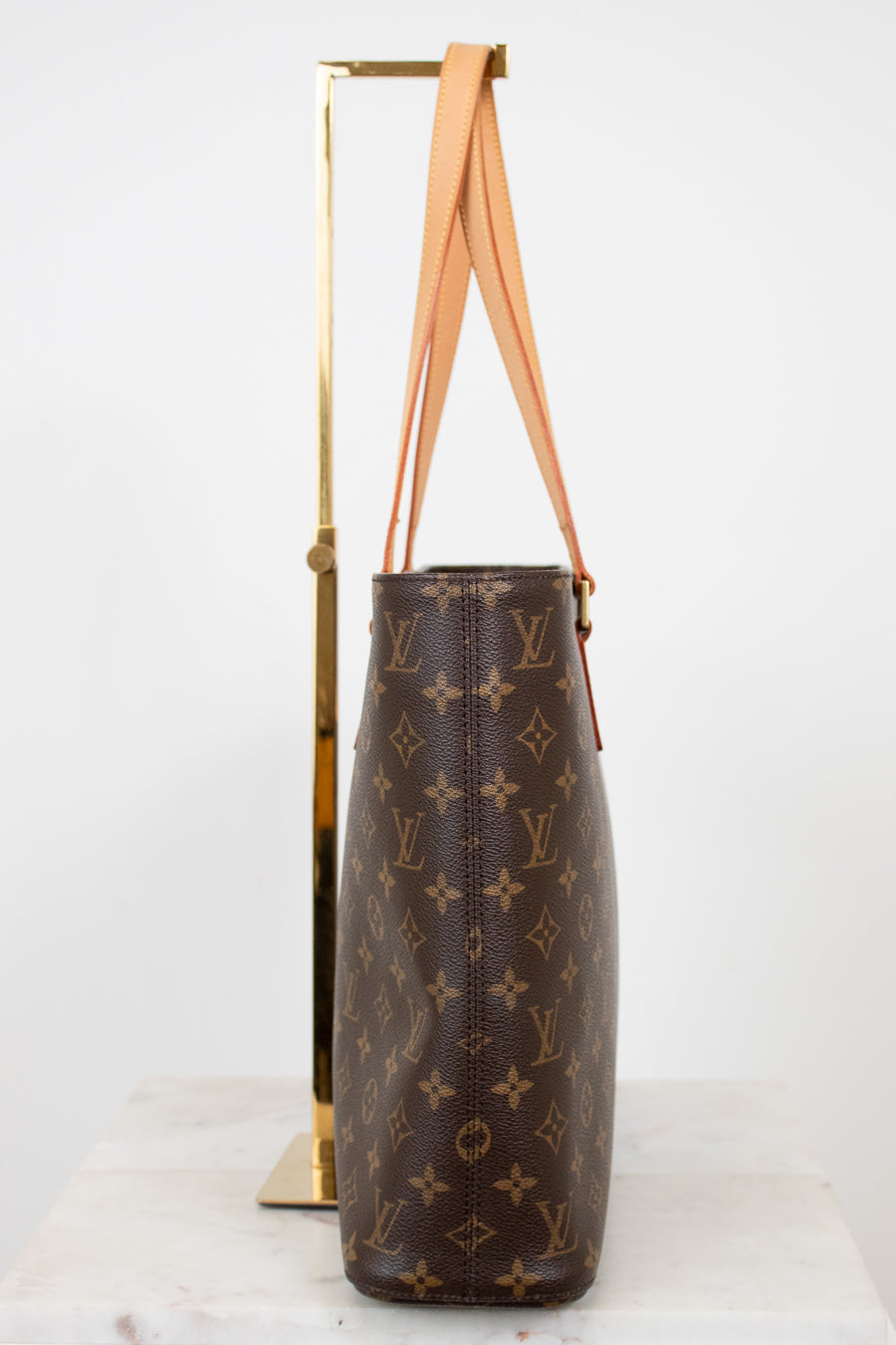 Brown monogram handbag with tan handles on a white background