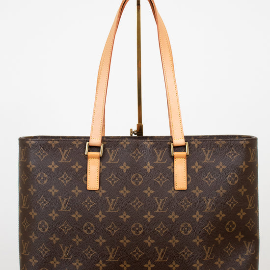 Brown monogram handbag with tan handles on a white background