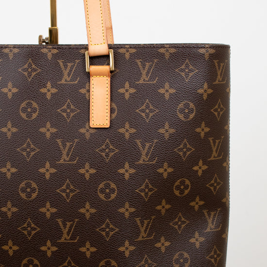 Brown monogram handbag with tan handles on a white background