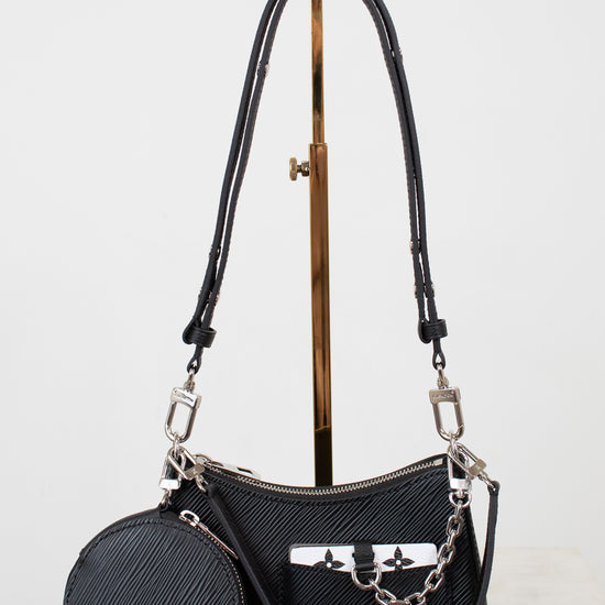 Black handbag with a matching round pouch on a light gray background