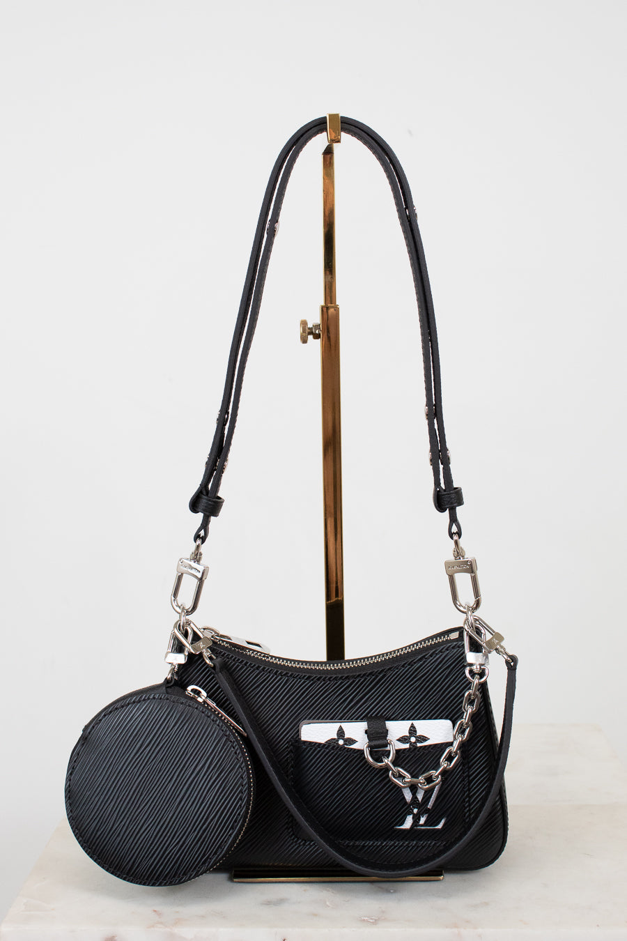 Black handbag with a matching round pouch on a light gray background