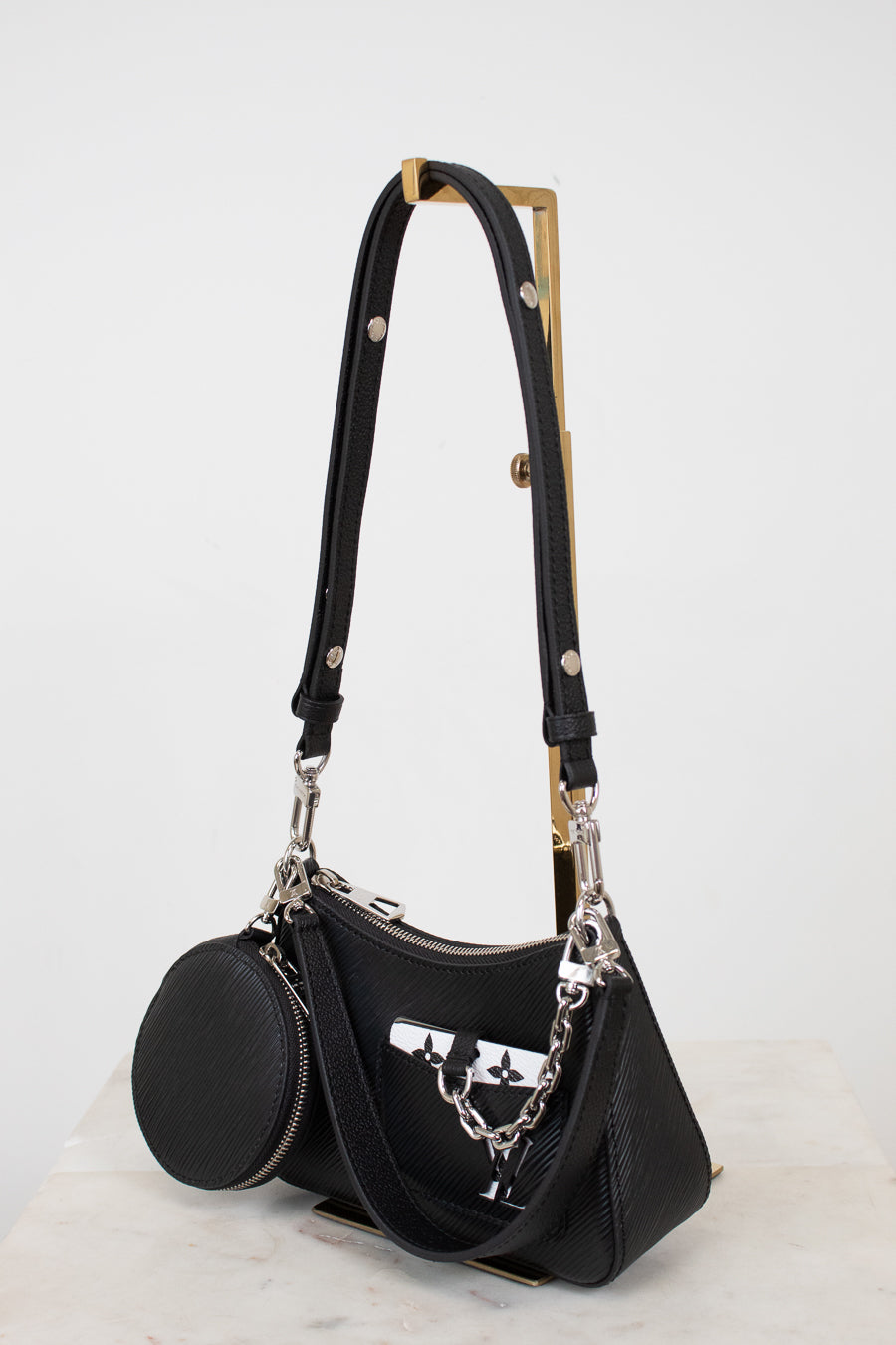 Black handbag with a chain detail on a white background