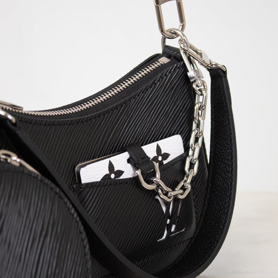 Black handbag with chain detail on a light gray background