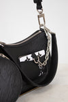 Black handbag with chain detail on a light gray background