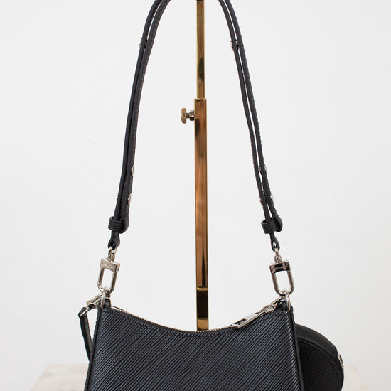 Black handbag with a strap on a white background