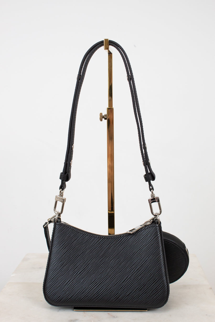 Black handbag with a strap on a white background