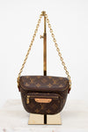 Louis Vuitton handbag with monogram pattern on a stand against a white background