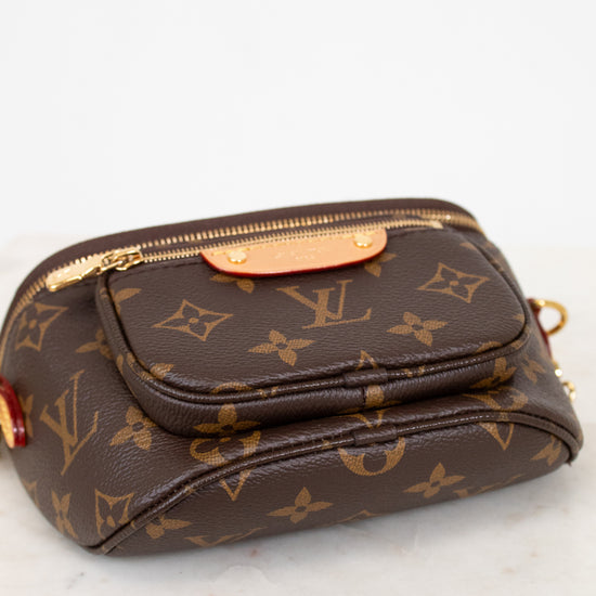 Brown Louis Vuitton handbag with monogram pattern on a white marble surface