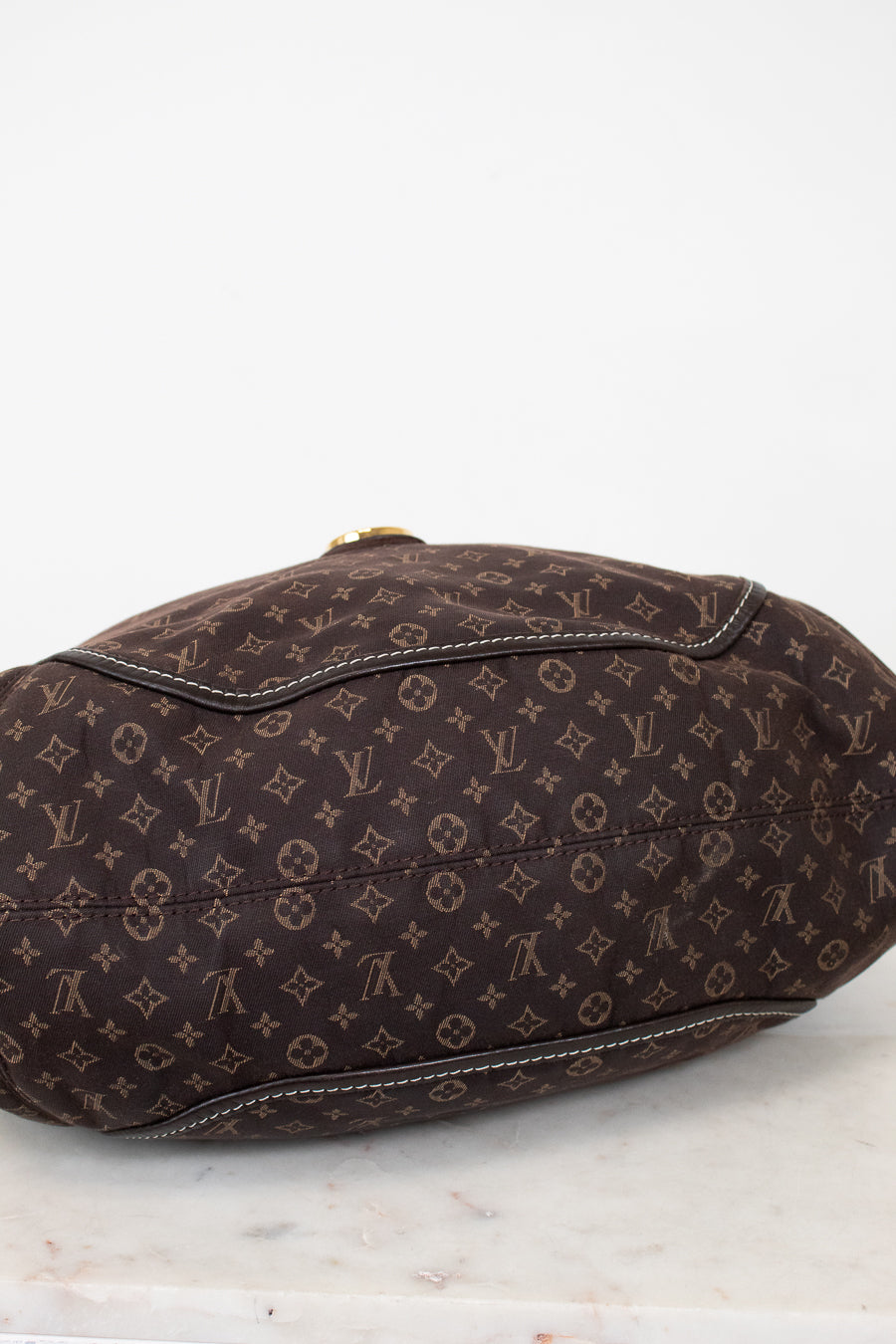 Brown monogram handbag on a white marble surface