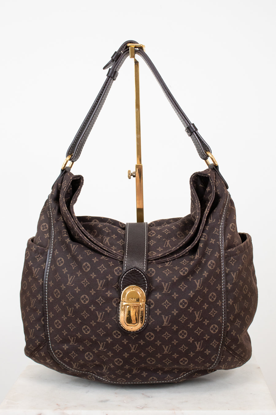 Brown handbag with gold accents on a white background