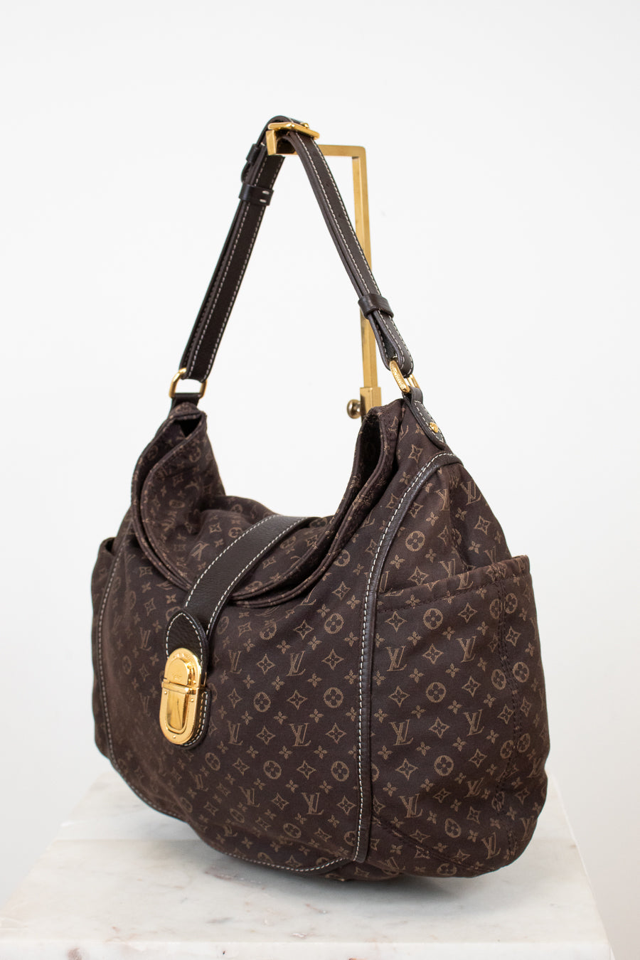 Brown handbag with gold accents on a white background