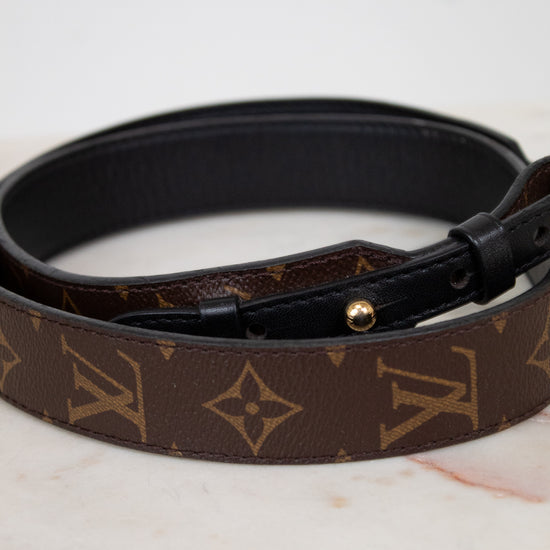 Louis Vuitton handbag strap with monogram pattern on a marble surface