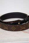 Louis Vuitton handbag strap with monogram pattern on a marble surface