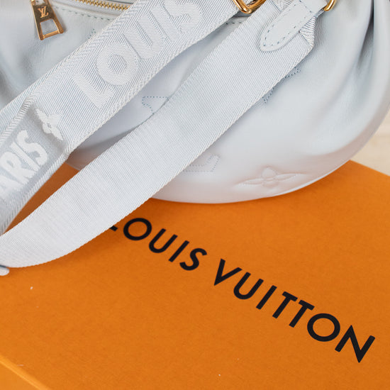 Light blue handbag with gold hardware on a Louis Vuitton box