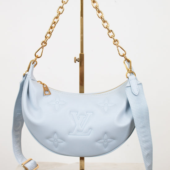 Light blue handbag with gold chain on a white background