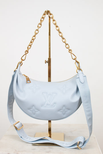 Light blue handbag with gold chain on a white background