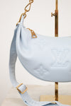 Light blue handbag with gold accents on a white background