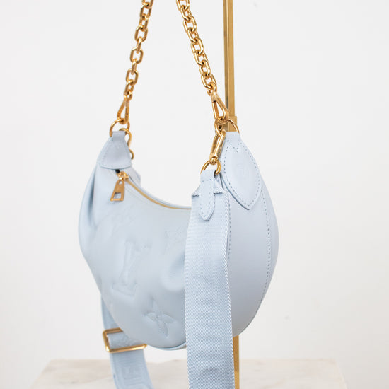 Light blue handbag with gold chain on a white background