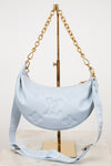 Light blue handbag with gold chain on a white background