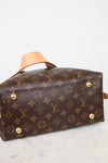 A Louis Vuitton monogram canvas handbag shown from a side angle on a light marble surface against a white background.