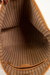 Close-up of the interior lining of a tan tote bag with thin vertical black pinstripes and a tan leather and gold-tone zipper.