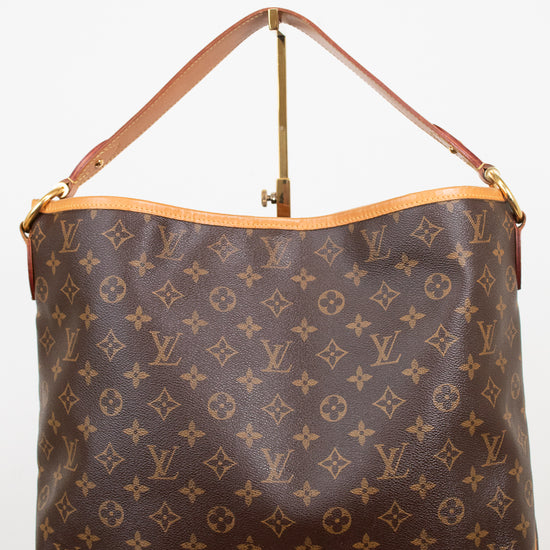 A Louis Vuitton monogram coated canvas shoulder bag with a tan leather strap and gold-tone hardware, displayed against a plain white background.