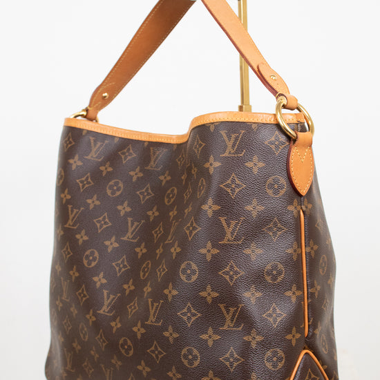 Louis Vuitton monogram coated canvas shoulder bag with tan leather trim and gold-tone hardware, photographed against a plain light background.
