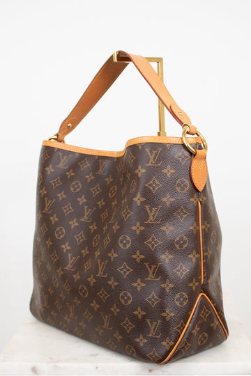 Louis Vuitton monogram coated canvas shoulder bag with tan leather trim and gold-tone hardware, photographed against a plain light background.