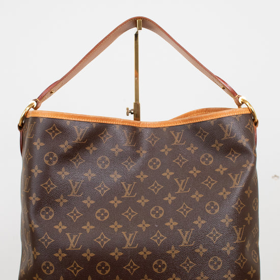 Louis Vuitton monogram coated canvas shoulder bag with a brown leather handle and gold-tone hardware, displayed against a plain white background.