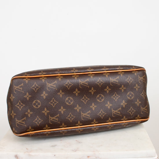A Louis Vuitton monogram coated canvas bottom view of bag, resting on a white marble block against a white background
