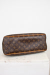 A Louis Vuitton monogram coated canvas bottom view of bag, resting on a white marble block against a white background