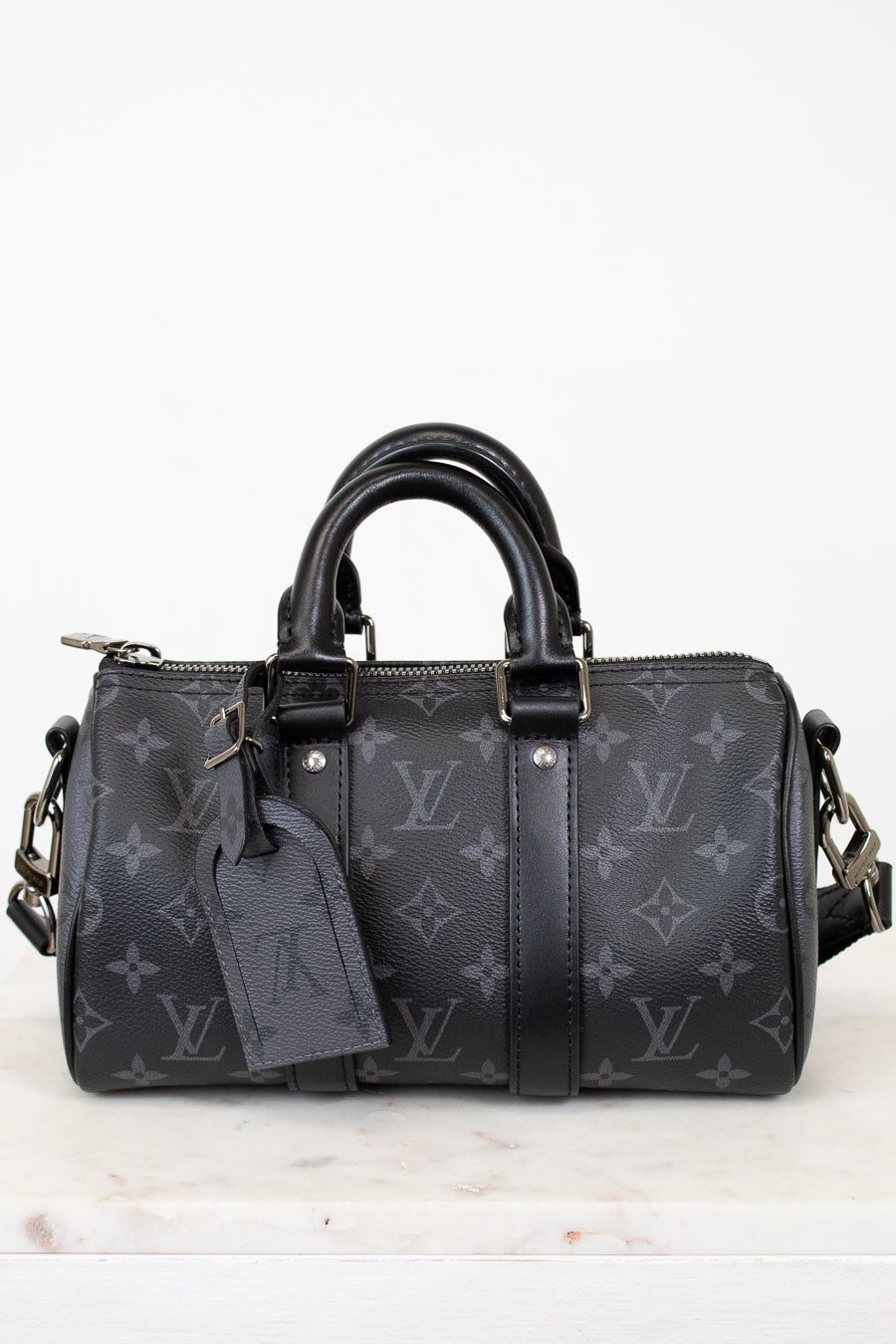 Black handbag with monogram pattern on a white background