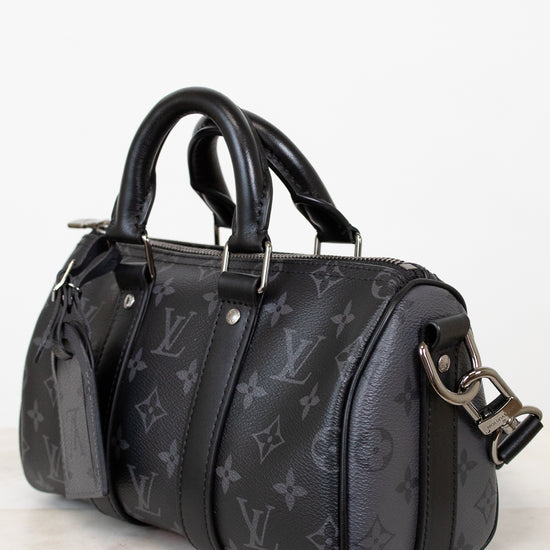 Black handbag with monogram pattern on a white background