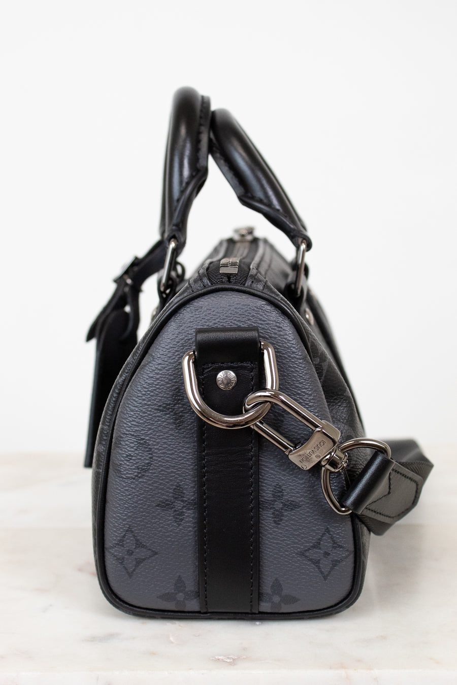 Black handbag with silver chain detail on a white background