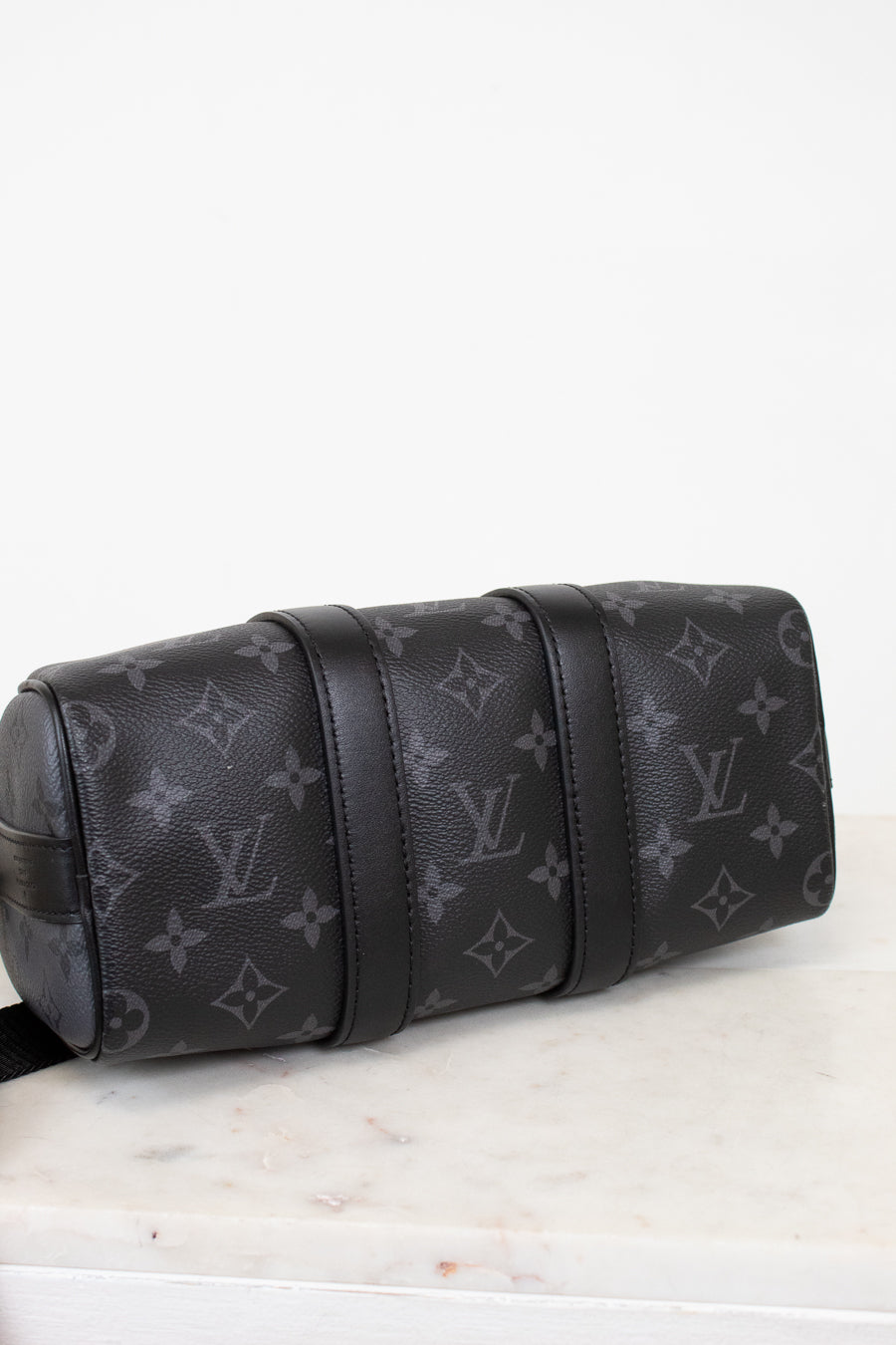 Black Louis Vuitton monogram bag on a white surface